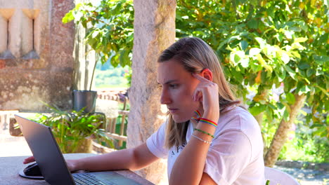 Porträt-Einer-Kaukasischen-Frau-Mit-Gay-Pride-Armband,-Die-Im-Garten-Telearbeit-Leistet