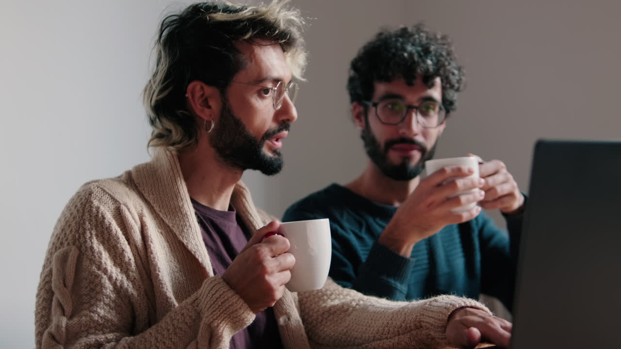 Gay Couple Working From Home on Laptop