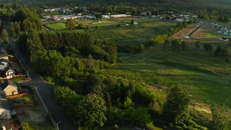 A-drone-pedestal-down-shot-with-a-tilt-up-on-a-small-town-during-sunset