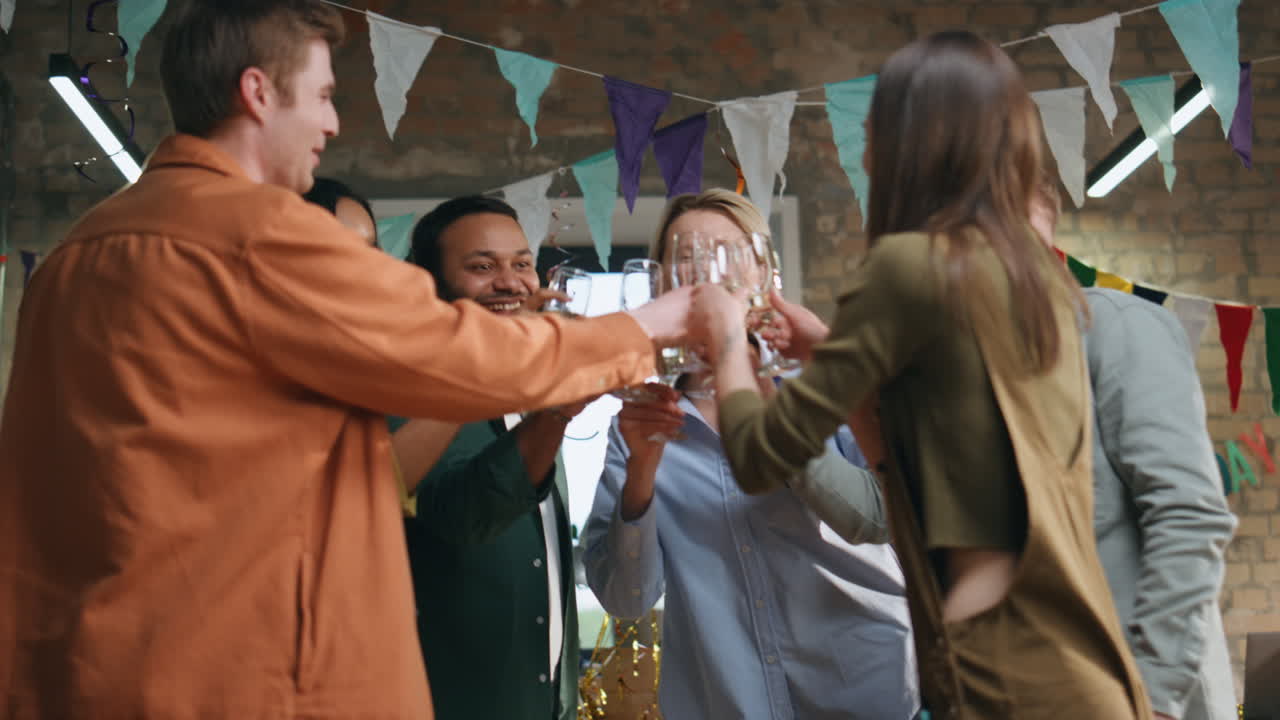 equipo riendo fiesta corporativa sonando copas de champán. colegas bebiendo