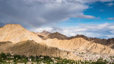 stunning clouds moving over leh valley with rainbow forming over an ancient monastery, ladakh india