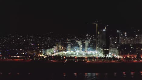 Night-view-of-skyscrapers-construction-at-Black-sea-beach-of-Batumi-city,-Georgia