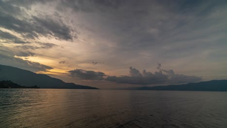 dramatic sunset over a serene lake with mountains