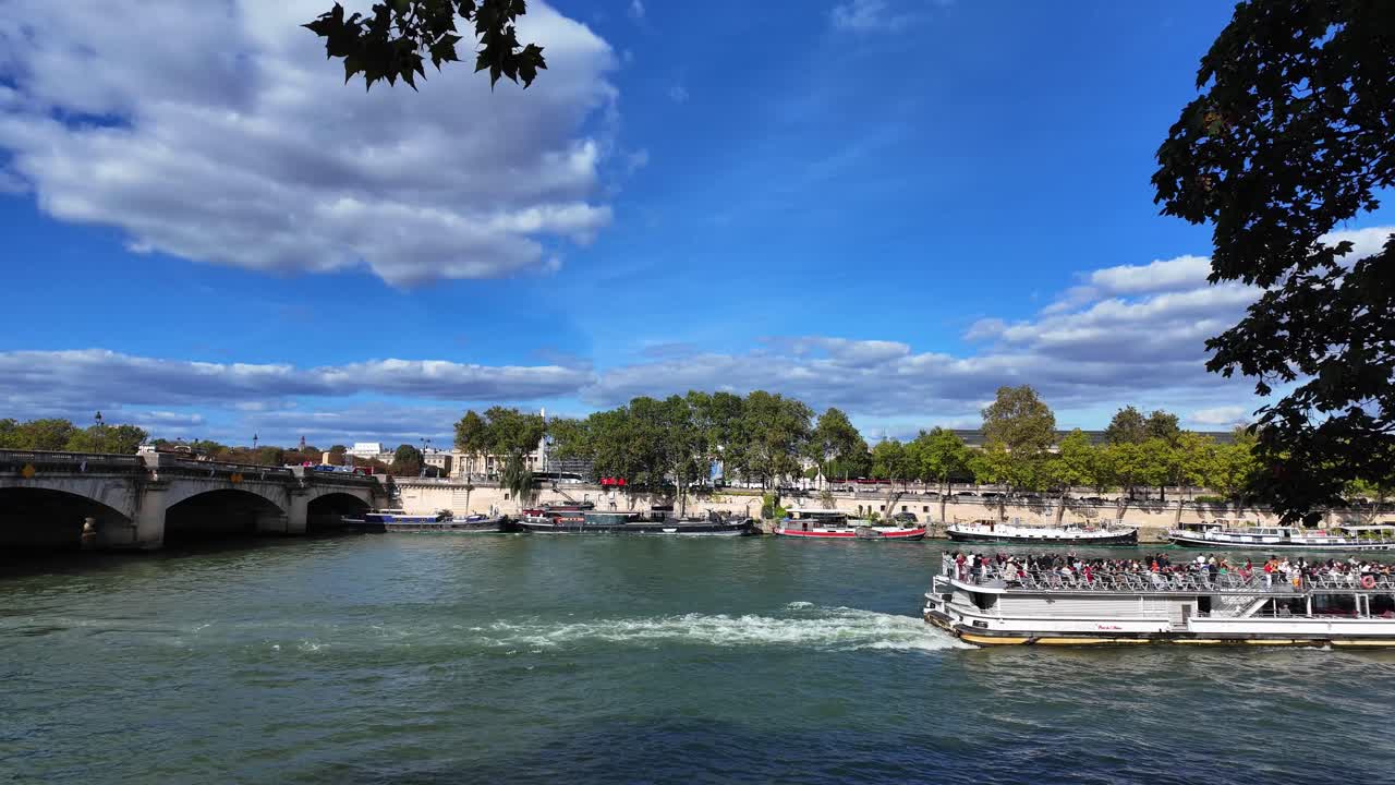 Cruise ship boat over Seine river Paris France city near bridge, blue cloudy skyline