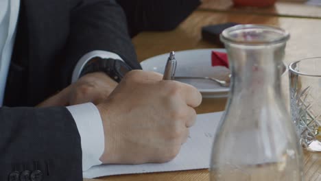 a businessman takes notes during a company meeting