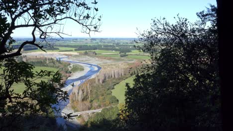 Light-and-shadow-contrast:-river-winding-through-flat-farmland-and-dense-native-bush---Ashley-Gorge-Skyline-Trail---New-Zealand