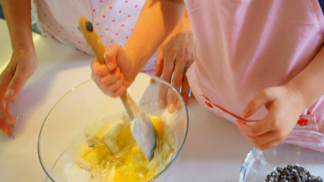 Front view of mother and daughter baking cookies in kitchen of comfortable home 4k