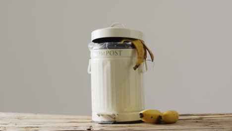 video of bunch of bananas and banana skin hanging out of full kitchen composting bin