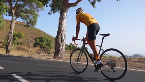 a guy is biking on a road with his road bike, engaging in outdoor exercise on a quiet morning. the concept of extreme sports is evident. the video is in slow motion