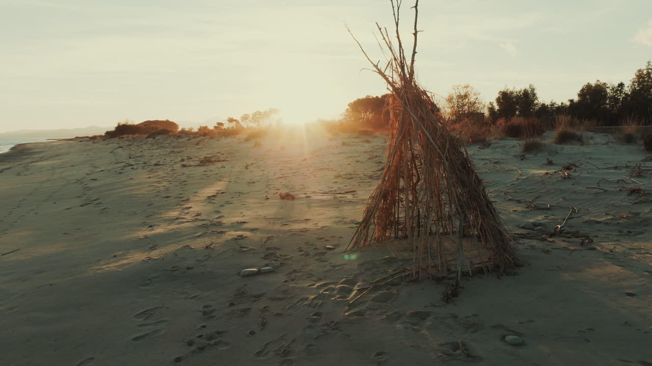 Reetgedeckte Hütte am Strand bei Sonnenuntergang am Strand in der Nähe des romantischen Ozeans