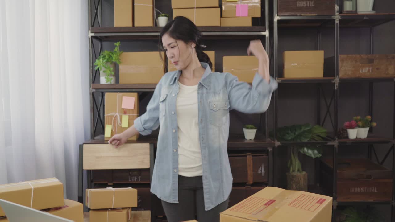 Beautiful smart Asian young entrepreneur business woman owner of SME feeling happy dancing while see business achievement. Small business owner at home office concept.
