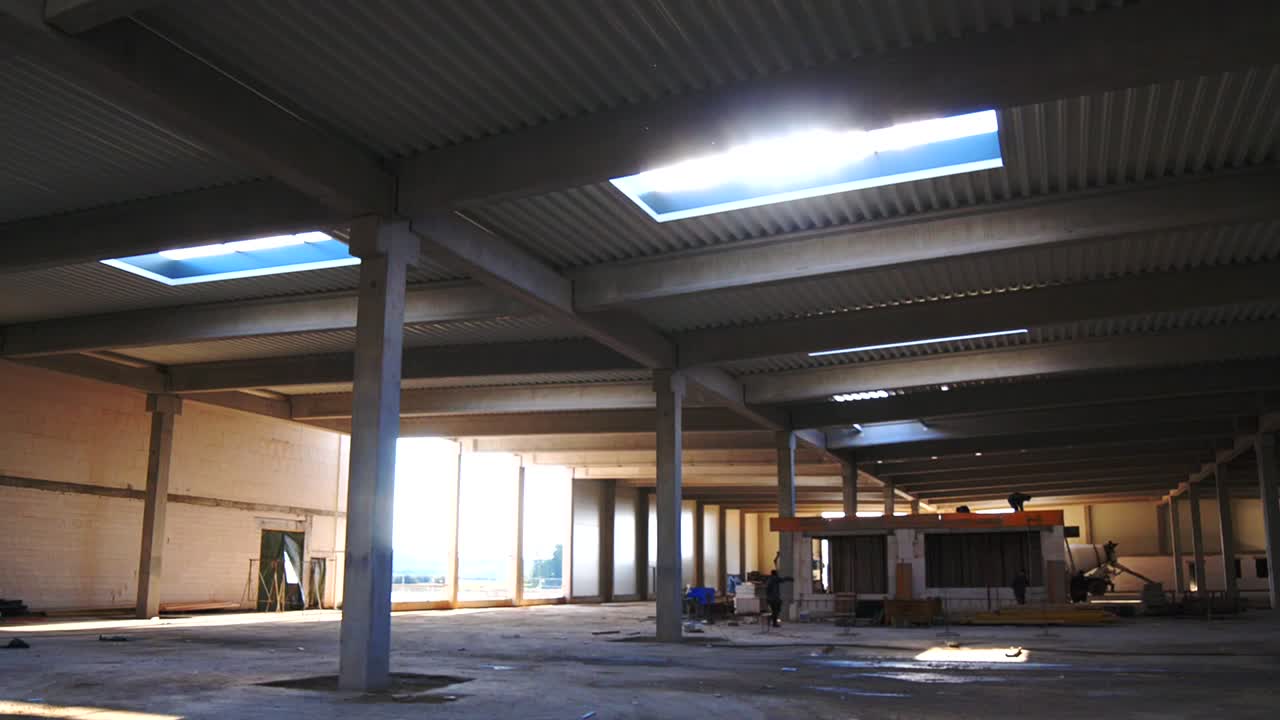 Il cantiere di un capannone con la luce del sole che filtra da un lucernario
