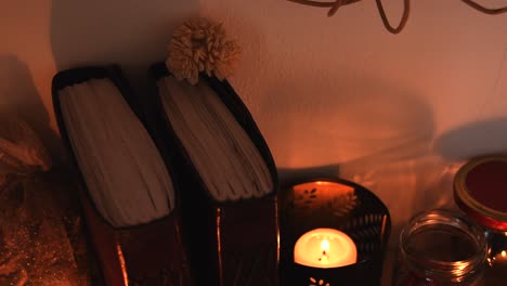 relaxing background detail shot of candles with flickering flames, some herbs, ancient books, jars and some dust flying around