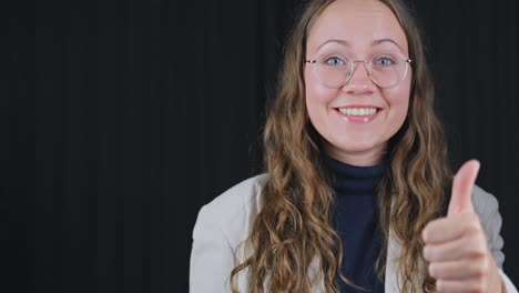 professionally dressed woman points at space and gives thumbs up approval and confident smile