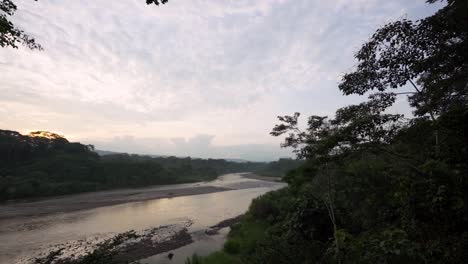 Langsame-Schwenkaufnahme-Des-Flusses-Misahualli-Bei-Sonnenuntergang-Und-Wolken-Am-Himmel