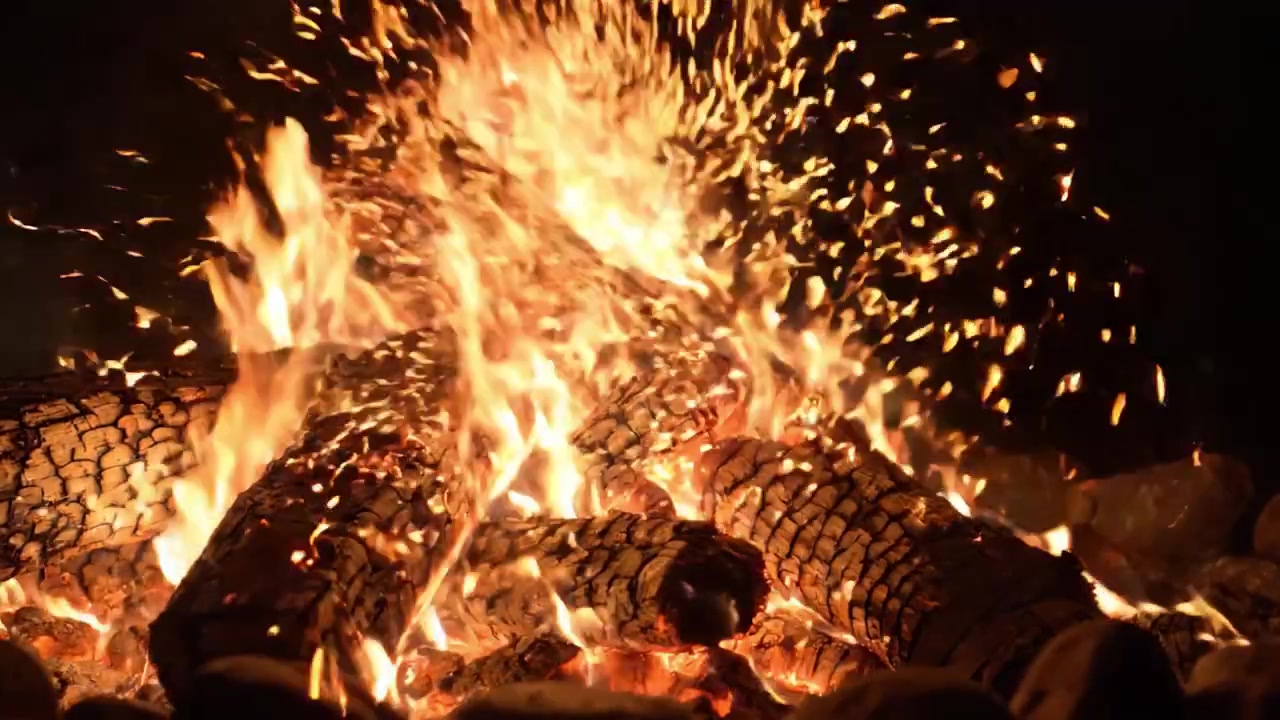Una scena di falò accattivante che mostra fiamme intense e tronchi carbonizzati, emanando calore e tranquillità sotto il cielo notturno stellato.