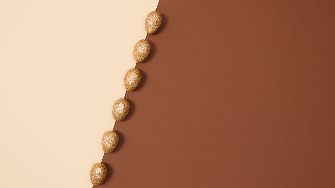 "미니멀 플래트 레이 (minimal flat lay) 는 ""아무것도 없는 갈색 배경 위에 회전하는 부활절 반이는 황금 달""이라는 개념이다."