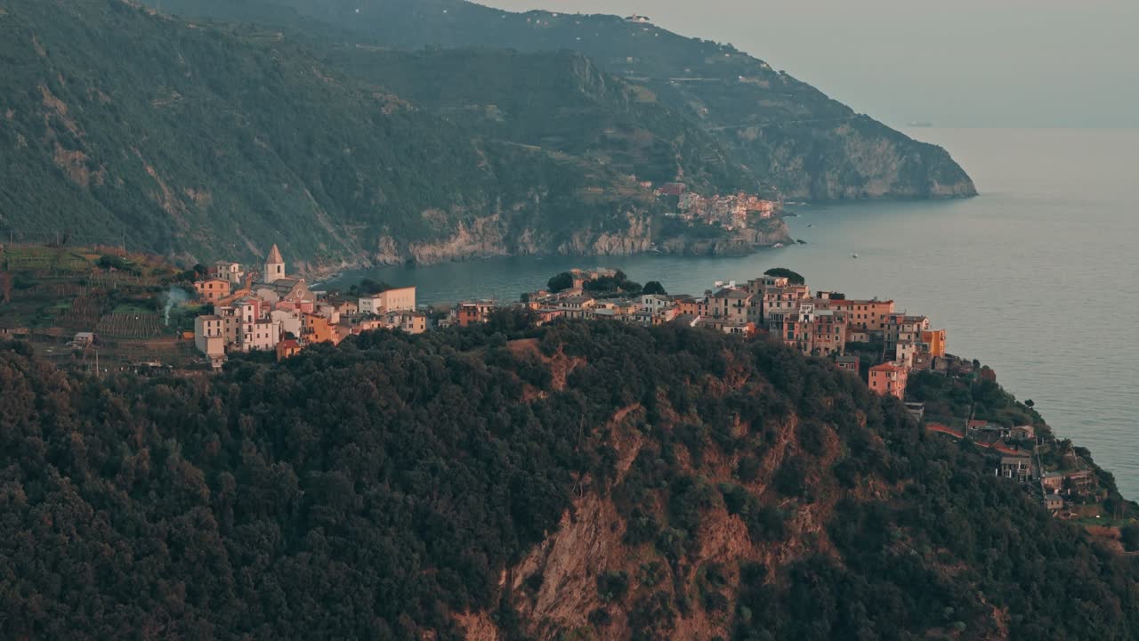 Flyover revealing Corniglia on the hill with warm Mediterranean sunset