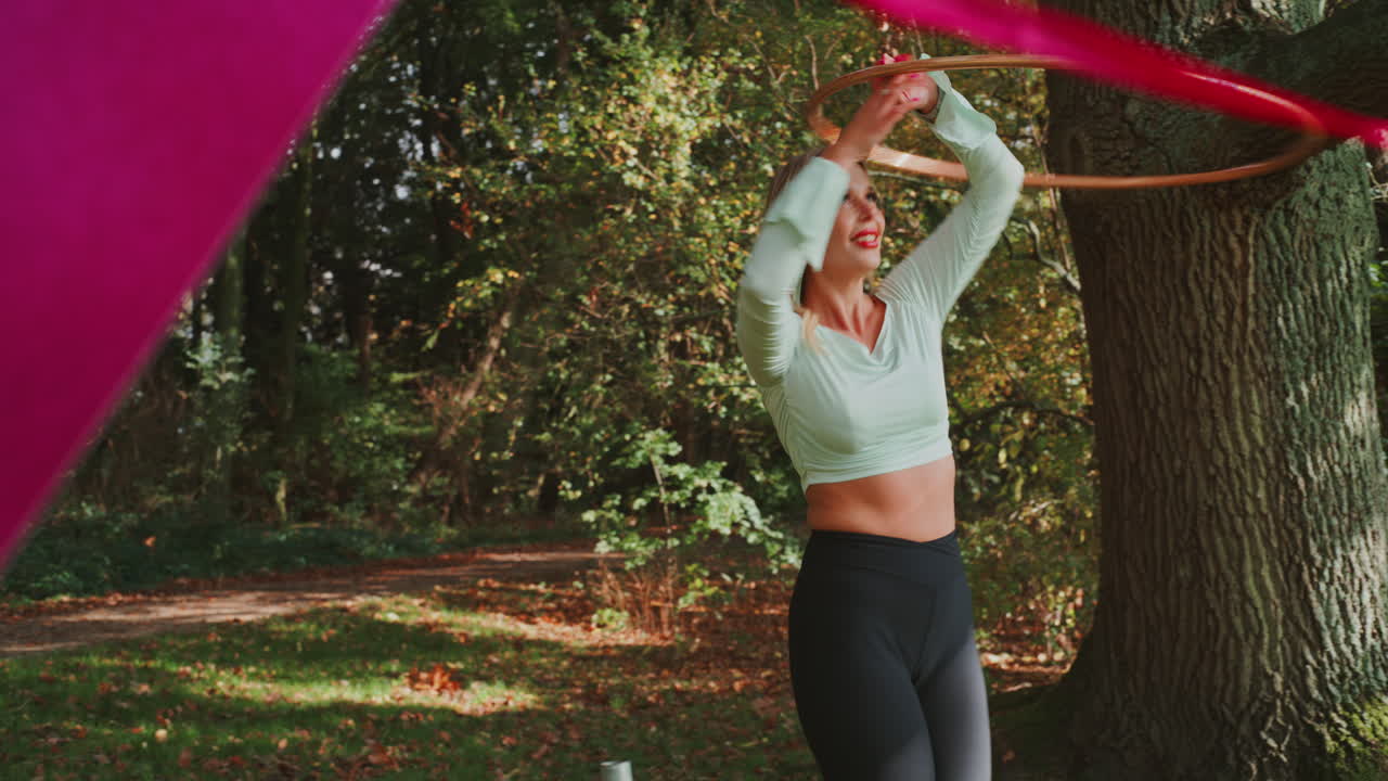 Woman Performing Hoop and Ribbon Routine Outdoors