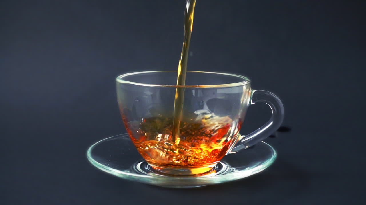 Il tè viene versato nella tazza. Movimento rallentato