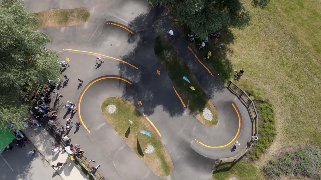 분주한 아스팔트 펌프 트랙과 아이들이 뛰어다닙니다.