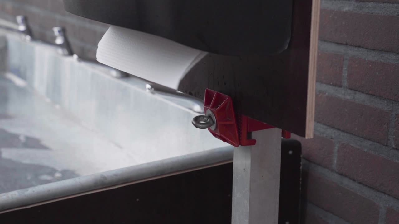 孩子手中拿着一用纸巾, 站在钢洗手盆旁边的分发器里