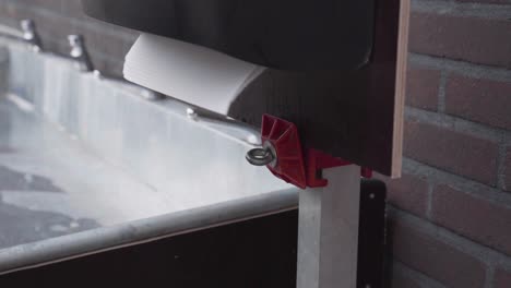 Child's-hands-takes-disposable-paper-tissue-from-the-dispenser-standing-outside-next-to-the-steel-sink