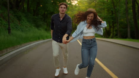 Energetic-couple-moving-fast-on-road-in-park.-Man-and-woman-having-fun-outdoors