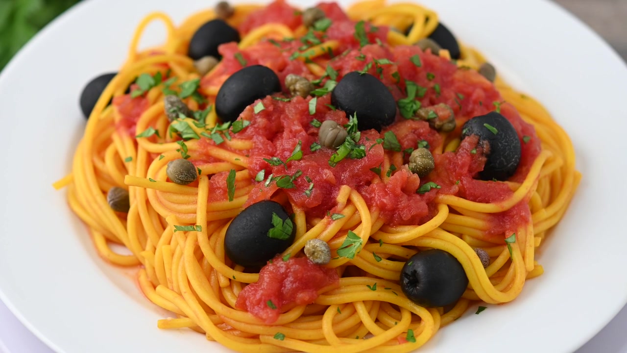 Pasta alla puttanesca italiana con salsa di pomodoro, capperi e olive nere