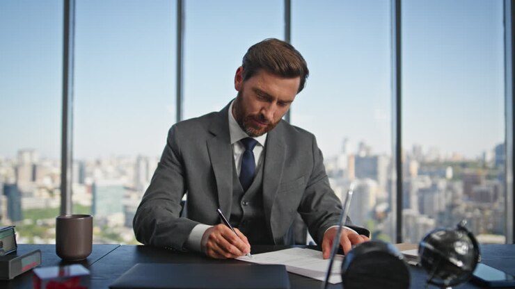 Confident businessman signing contract at desk. Smiling financial manager work