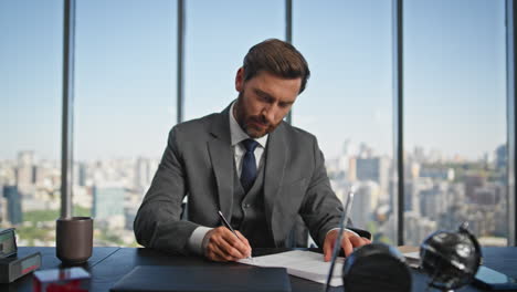 hombre de negocios confiado firmando contrato en el escritorio. sonriente trabajo de gerente financiero