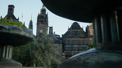 Town-hall-in-distance-shot-through-fountains-at-Peace-Gardens-Sheffield-City-Centre-Sheffield-Town-Hall-Main-central-building-key-location-land-mark-tourist-attraction-clock-tower-4K-25p