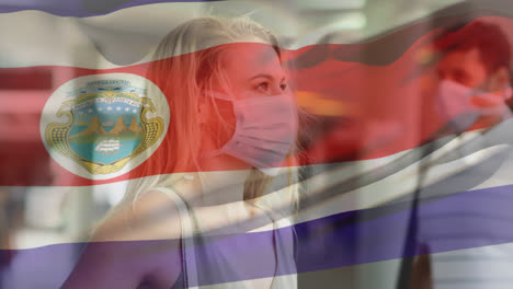 Animation-of-flag-of-costa-rica-waving-over-woman-wearing-face-mask-during-covid-19-pandemic