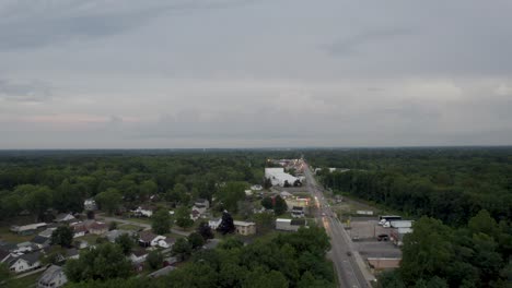 A-drone-shot-of-a-beautiful-busy-highway-surrounded-by-beautiful-meadow-and-few-small-houses-are-seen-alongside-of-the-road