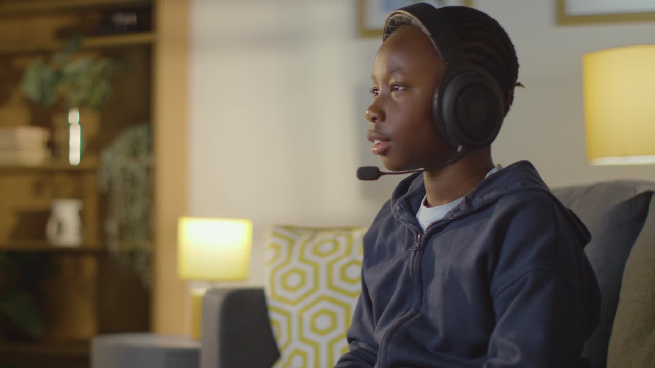 Boy At Home Sitting On Sofa Wearing Headset Playing Video Game 3