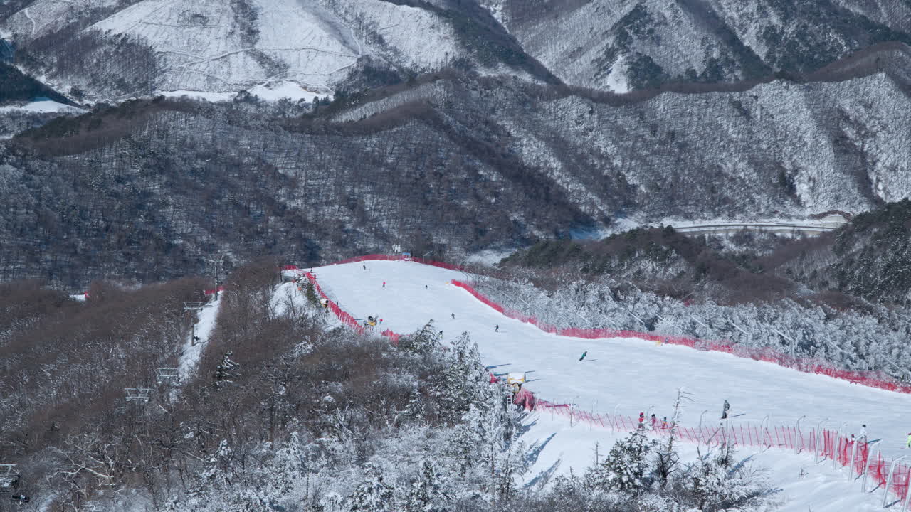 Skiers Skiing Down the Hill of Balwangsan Mountain Slopes in Yong Pyong Ski Resort Pyeongchang-gun - Aerial High Angle Pan