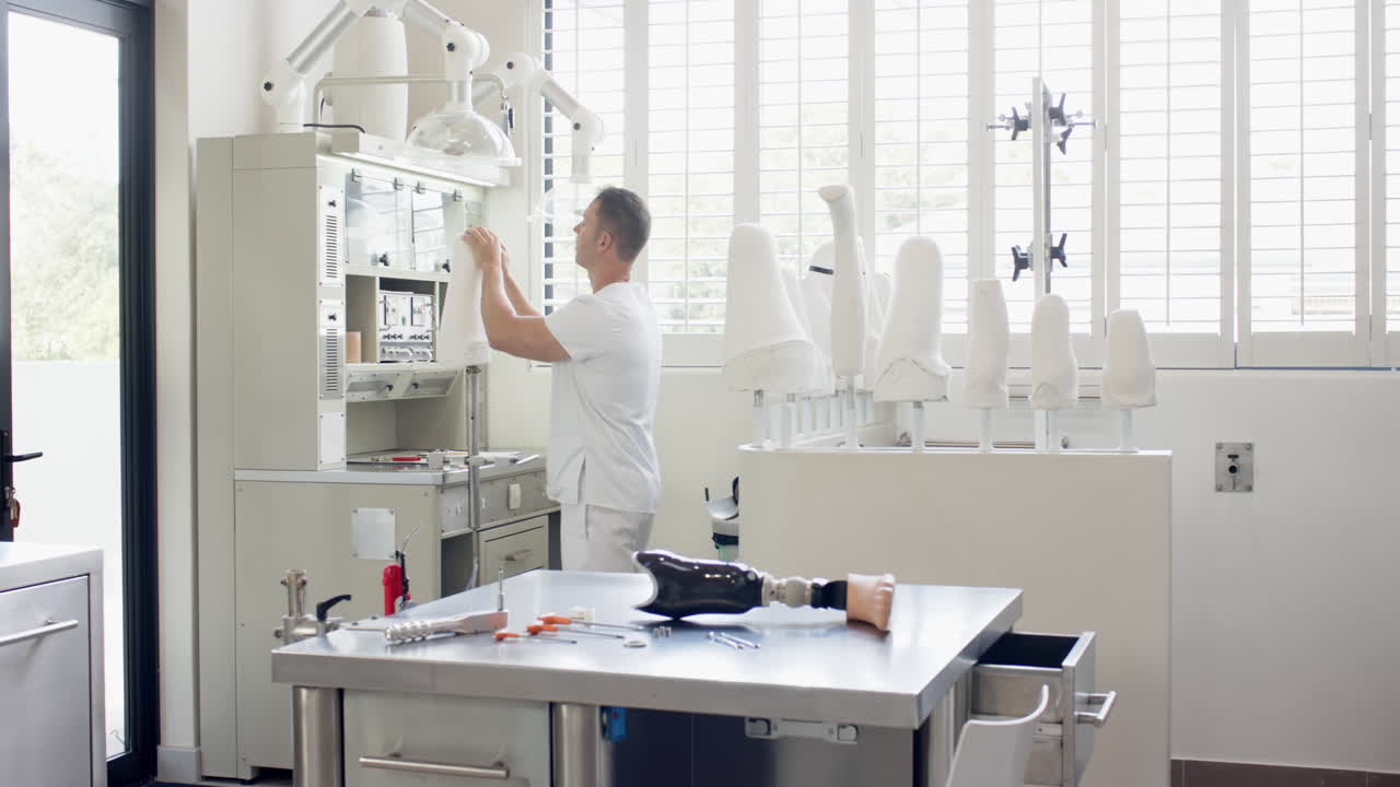 Working in prosthetic lab, technician adjusting equipment with tools on table