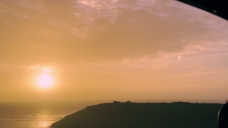 Zooming-through-car's-window-towards-sun-rising-over-ocean