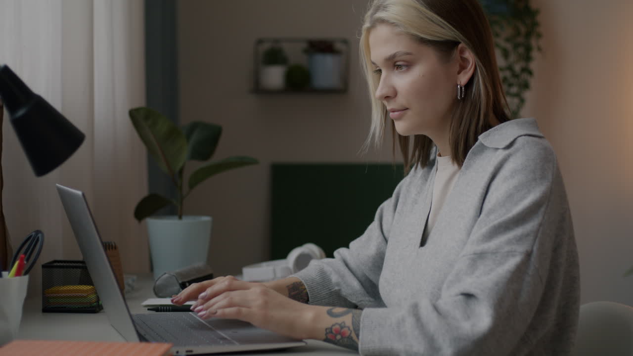 молодая женщина работает на ноутбуке дома