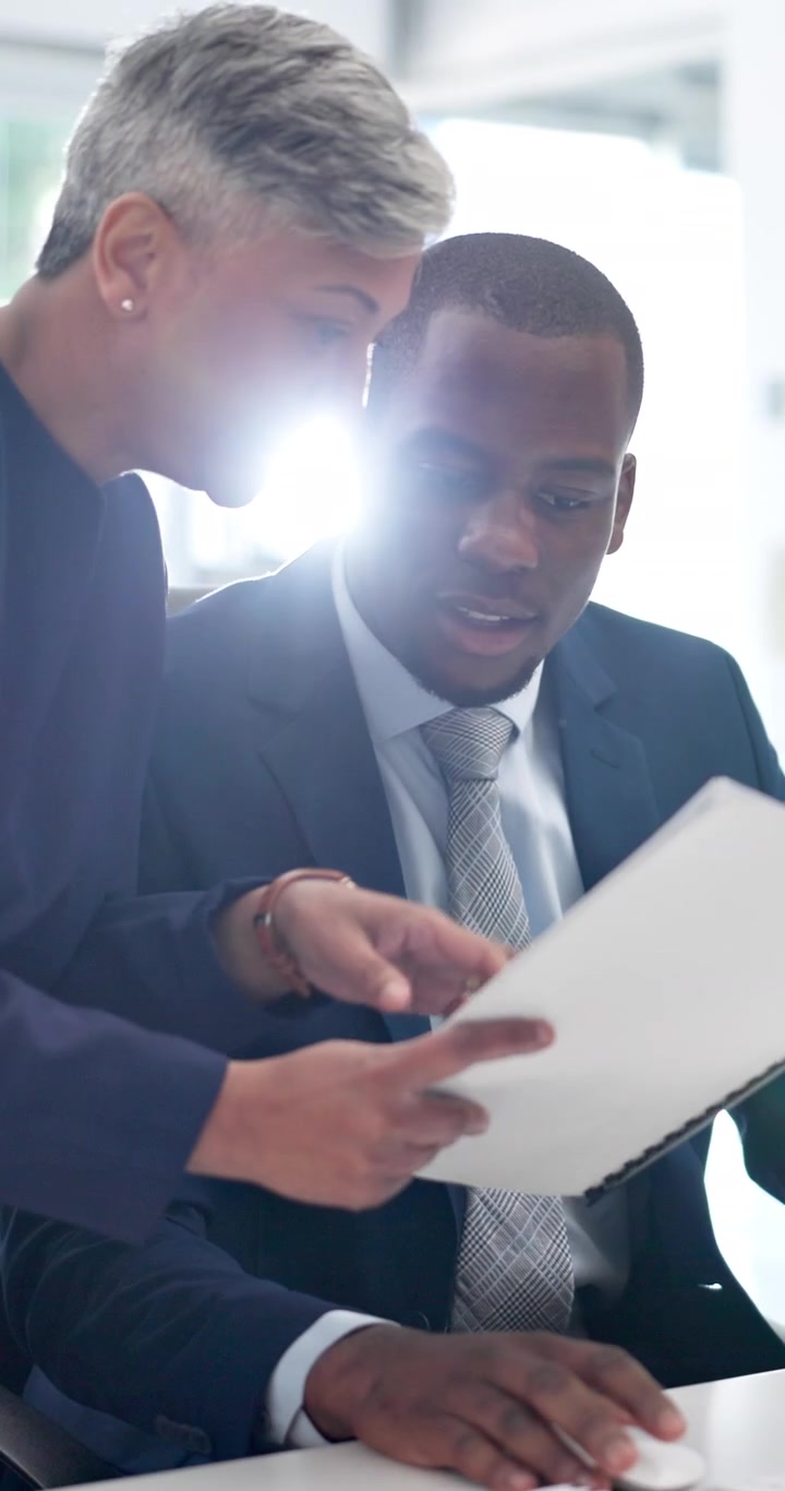 Business Professionals Collaborating on Documents in Modern Office