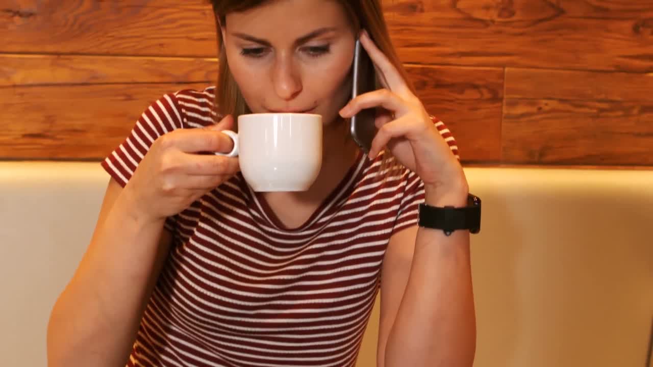 mujer tomando un café mientras habla por teléfono