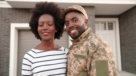 a soldier and his wife are in the porch of their home