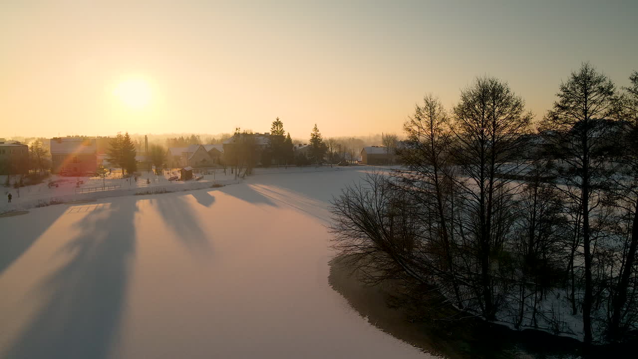 백그라운드에서 일출과 함께 눈 덮인 호수와 도시 실루엣 위로 공중 역방향 비행