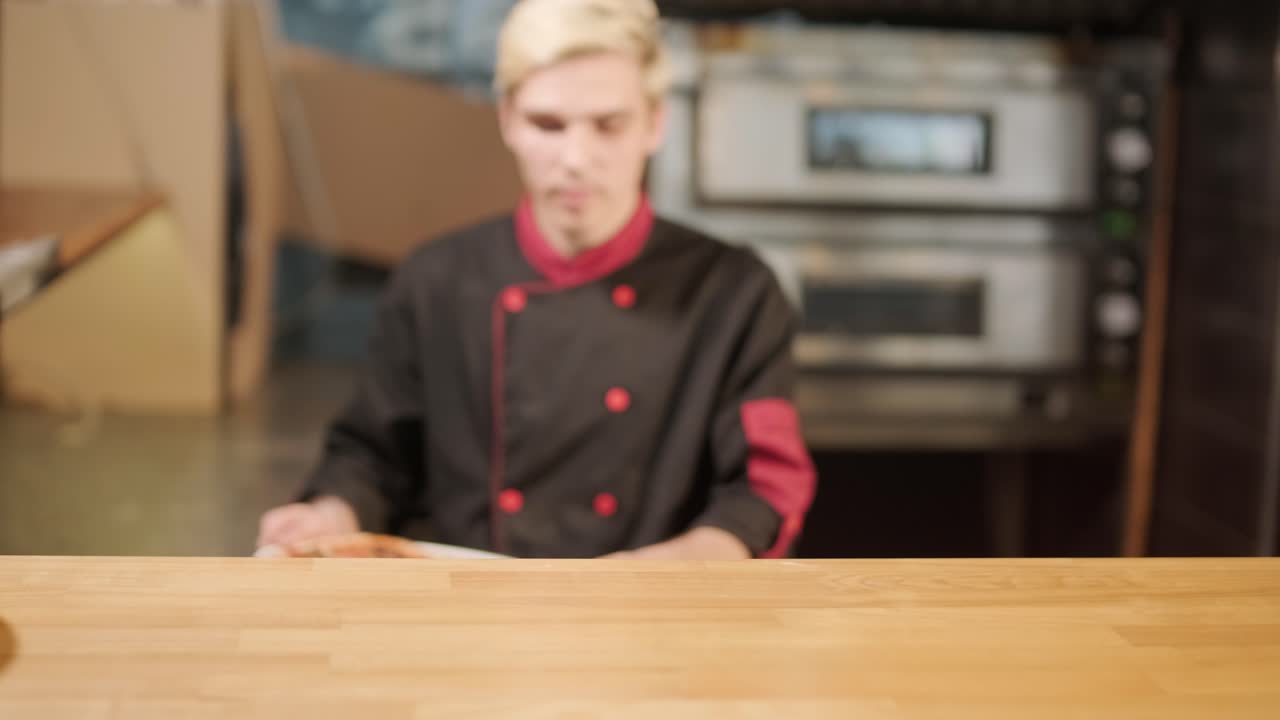 hombre cocinando pizza en la cocina de un restaurante