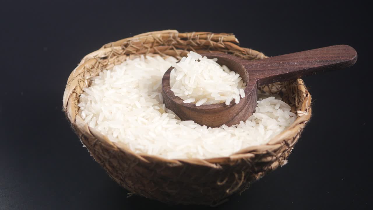 arroz crudo en un cuenco con cuchara de madera