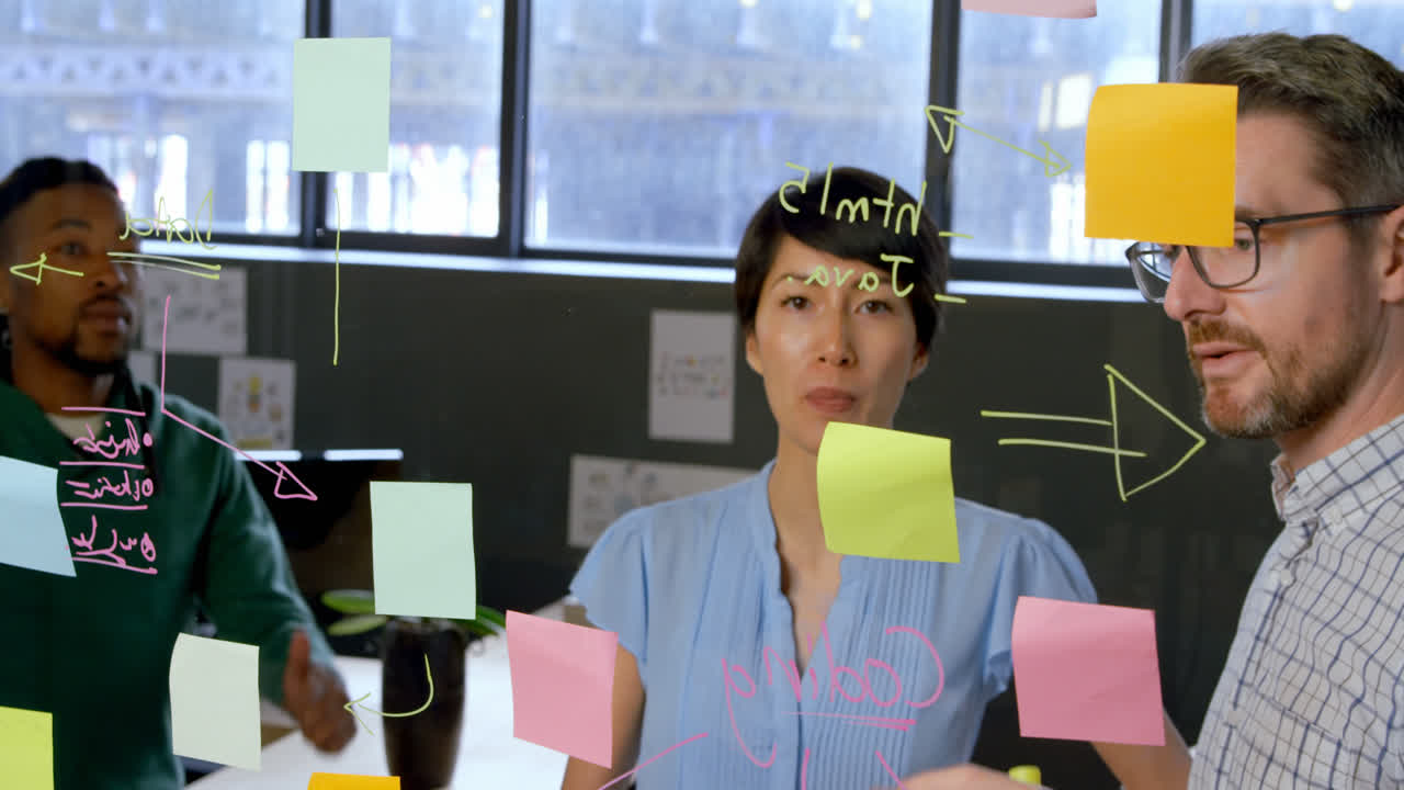 Business executives discussing over glass wall in office 4k