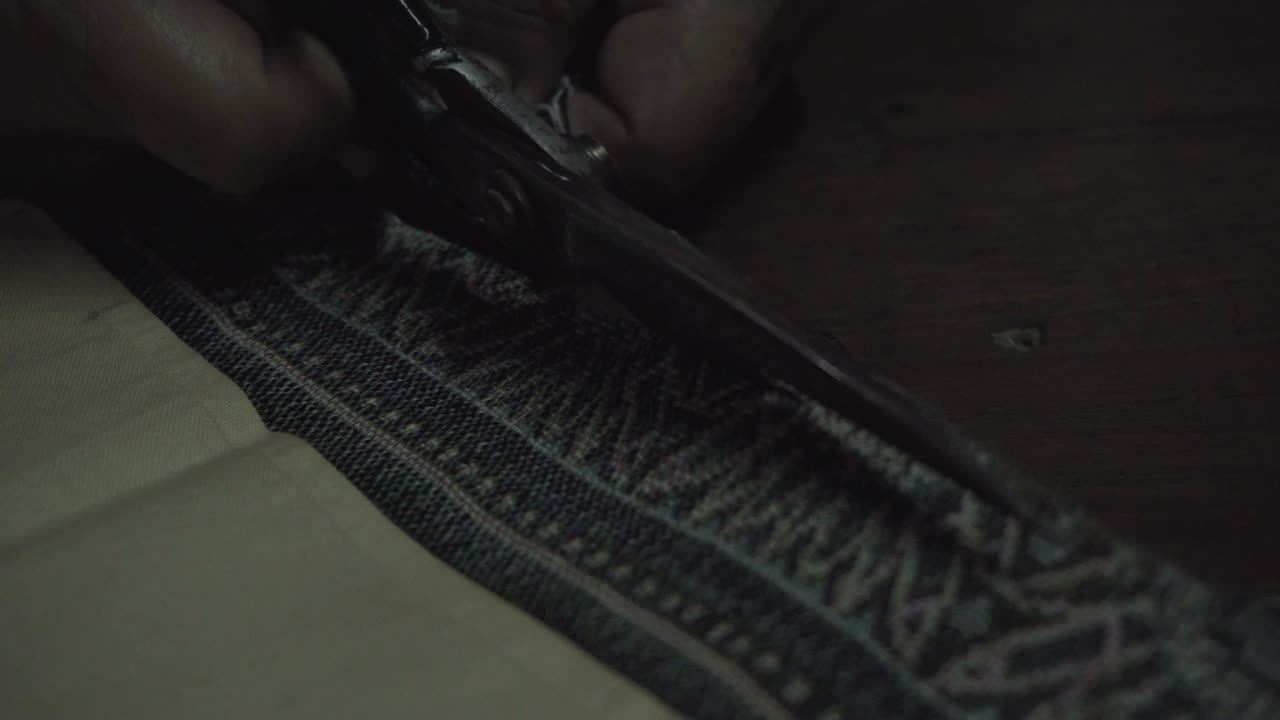 mira de cerca, la vieja sastre usa tijeras para cortar la tela tradicional tailandesa