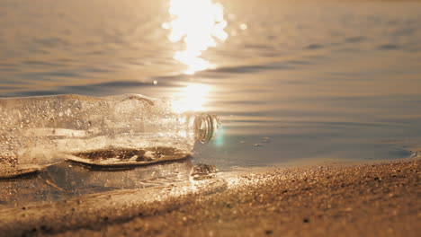 Plastikmüll-An-Der-Küste-Die-Flasche-Liegt-Am-Rand-Des-Wassers