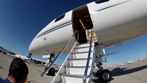 a private jet with its boarding stairs extended and a red carpet being unfurled