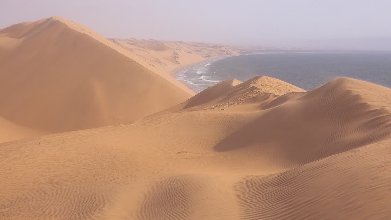 fuertes vientos soplan a través de las asombrosas dunas de arena del desierto de namib a lo largo de la costa esquelética de namibia 3